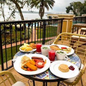 Breakfast laid on a balcony table overlooking the pool and the lake