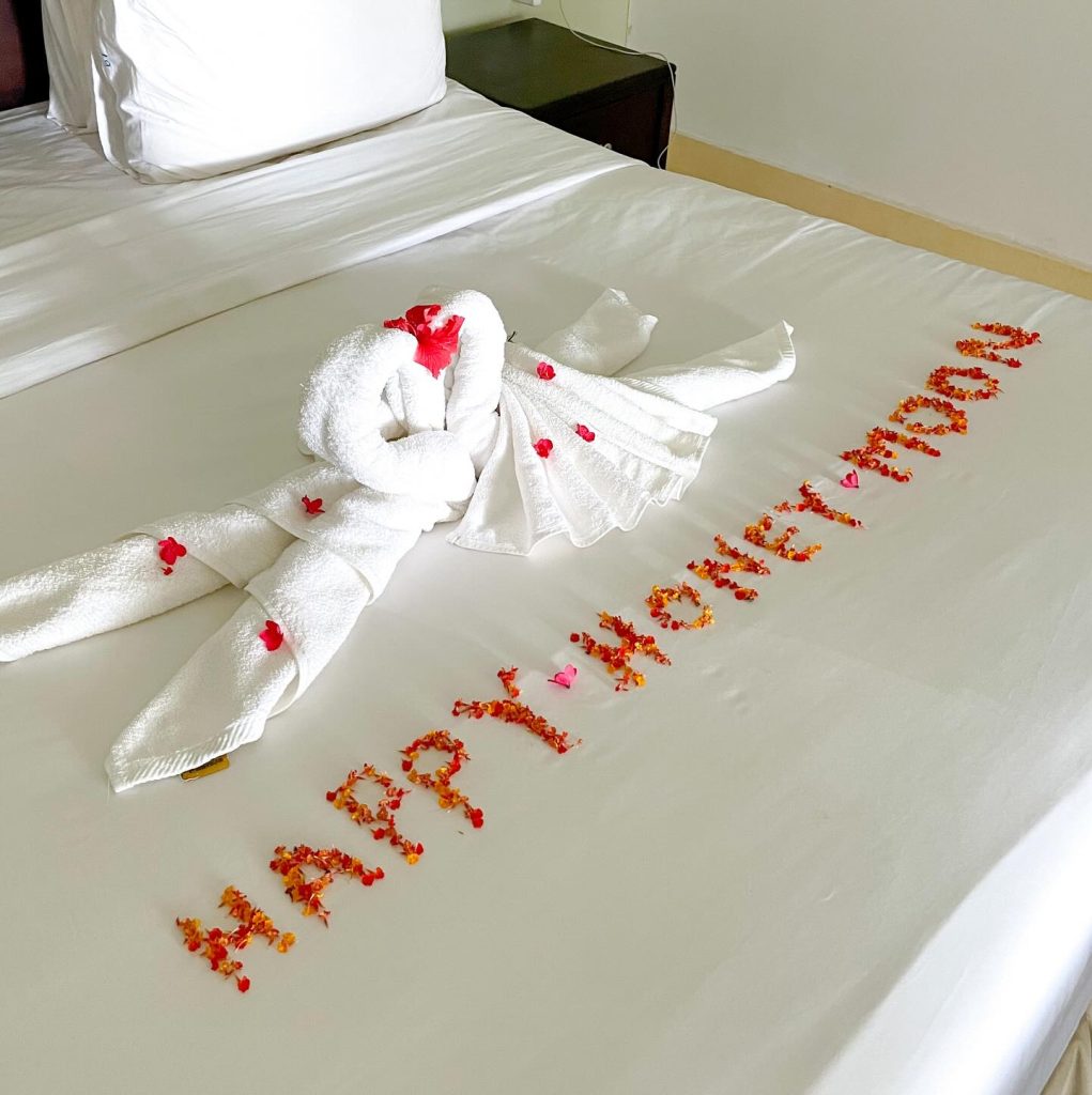 Honeymoon turndown with towel swans and a petal message on the bed